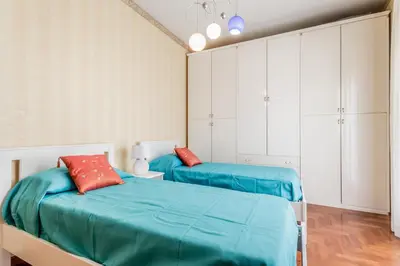 a bedroom with two beds and white cabinets at Casa da Annarella in Rome