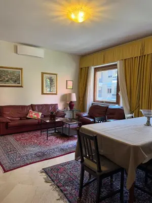 a living room with a table and a couch at St Peter Rooms with Private Parking by Dama in Rome
