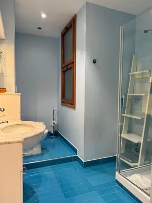a bathroom with a toilet and a blue tile floor at St Peter Rooms with Private Parking by Dama in Rome