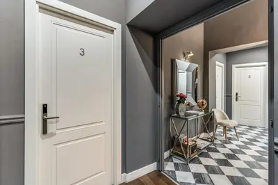 a hallway with a white door and a checkered floor at Little Queen Relais in Rome