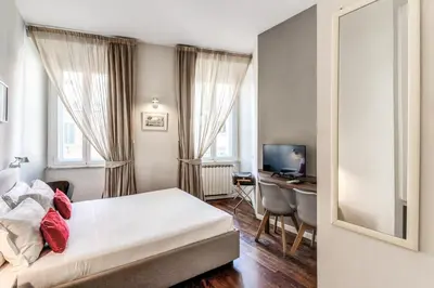 a hotel room with a bed and a desk at Little Queen Relais in Rome