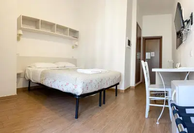 a bedroom with a bed and a table and a desk at B&B Mazzini in Rome