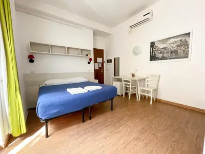 a bedroom with a blue bed and a table at B&B Mazzini in Rome