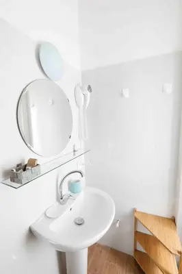 a white bathroom with a sink and a mirror at B&B Mazzini in Rome