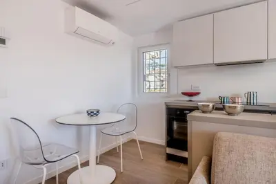 a white kitchen with a table and chairs in it at APT ROME Sergio I - San Pietro Vatican in Rome