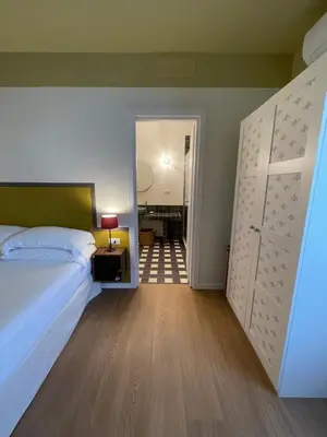 a bedroom with a bed and a door to a bathroom at Flowers Rooms - Ponte Milvio in Rome