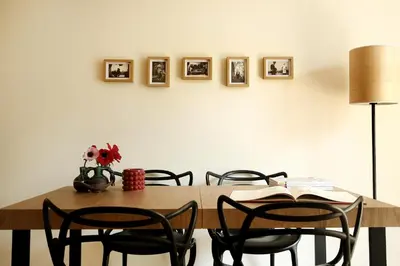 a dining room table with chairs and pictures on the wall at Flowers Rooms - Ponte Milvio in Rome