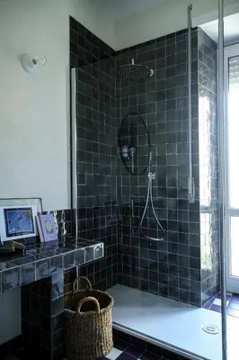 a black tiled bathroom with a shower and a sink at Flowers Rooms - Ponte Milvio in Rome