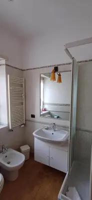 a bathroom with a sink and a toilet and a mirror at Lively House in Rome