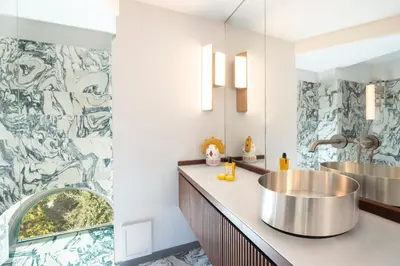 a bathroom with two sinks and a mosaic wall at Dimora della Luna in Rome