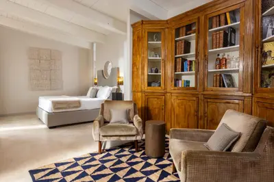 a bedroom with a bed and a couch and chairs at Dimora della Luna in Rome