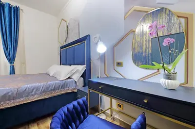 a bedroom with a bed and a blue chair at Just Chilling Ferruccio in Rome