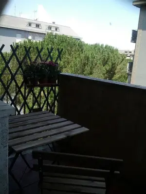 a wooden bench sitting on a balcony with a flower planter at Vacanze romane in Rome
