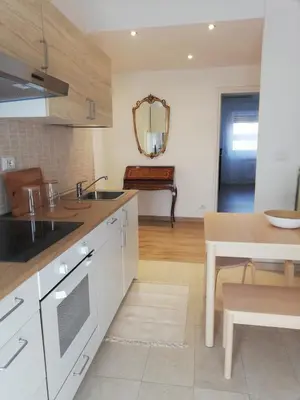 a kitchen with white cabinets and a sink and a table at Vacanze romane in Rome