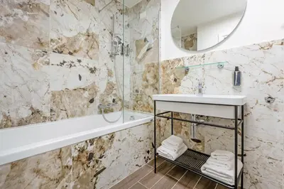 a bathroom with a tub and a sink and a mirror at Dei Greci Guesthouse in Rome