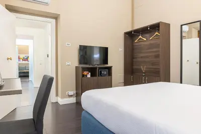 a bedroom with a bed and a flat screen tv at Dei Greci Guesthouse in Rome