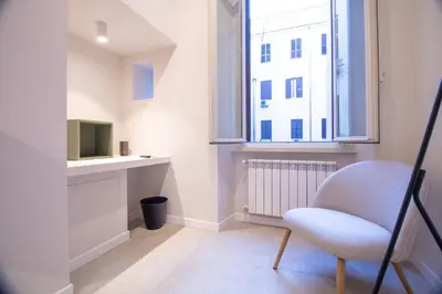 a living room with a chair and a window at Cunabu Emilio in Rome