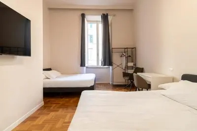 a hotel room with two beds and a television at Cunabu Emilio in Rome