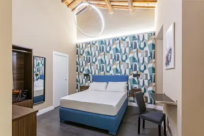 a bedroom with a bed and a desk and a chair at Maison dei Greci in Rome