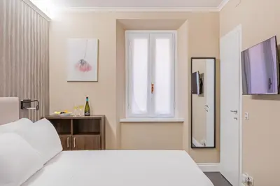 a bedroom with a white bed and a window at Maison dei Greci in Rome