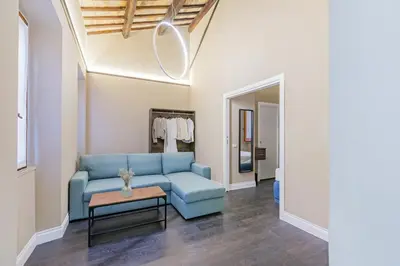 a living room with a blue couch and a table at Maison dei Greci in Rome