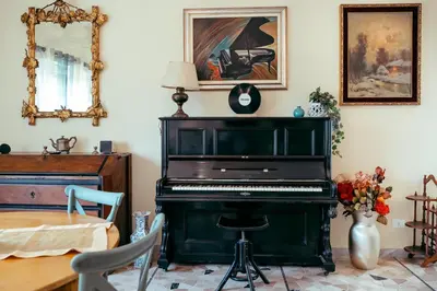 a green piano in a room with a table and a mirror at Eleganza e Arte a Città Giardino 5' Metro B in Rome