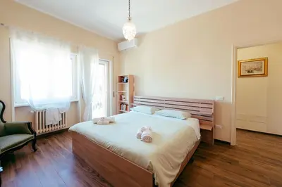 a bedroom with a large bed and a chair at Eleganza e Arte a Città Giardino 5' Metro B in Rome