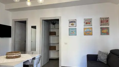 a living room with a white wall with posters on it at Angoletto di Mirtilla in Rome