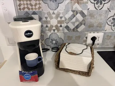 a coffee maker on a counter next to a stack of towels at Angoletto di Mirtilla in Rome