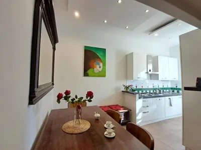 a kitchen and dining room with a wooden table with flowers at Wonderful Garden at Colosseo in Rome