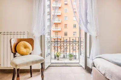 a bedroom with a chair and a large window at Wonderful Garden at Colosseo in Rome
