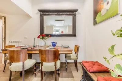 a dining room with a table and chairs and a mirror at Wonderful Garden at Colosseo in Rome