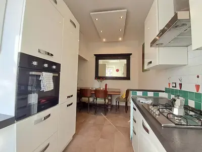 a kitchen with white cabinets and a stove top oven at Wonderful Garden at Colosseo in Rome