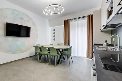 a kitchen and dining room with a table and chairs at BDC - Mariposa 3BDR in San Giovanni in Rome