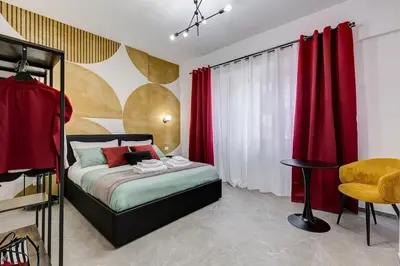 a bedroom with a bed with red curtains and a chair at BDC - Mariposa 3BDR in San Giovanni in Rome