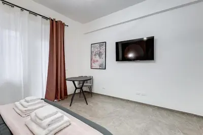 a bedroom with a bed and a tv on a wall at BDC - Mariposa 3BDR in San Giovanni in Rome