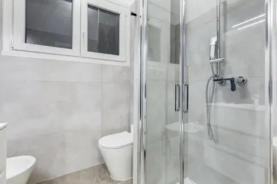 a bathroom with a toilet and a glass shower at BDC - Mariposa 3BDR in San Giovanni in Rome