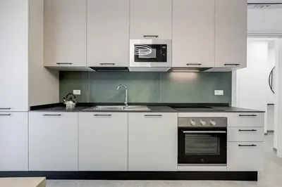 a white kitchen with a sink and a microwave at BDC - Mariposa 3BDR in San Giovanni in Rome