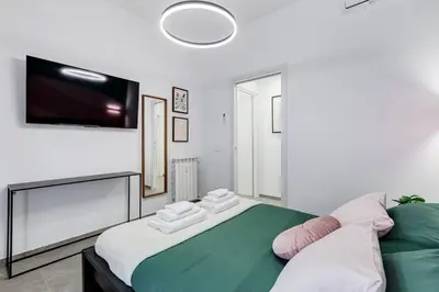 a bedroom with a large bed with a flat screen tv at BDC - Mariposa 3BDR in San Giovanni in Rome