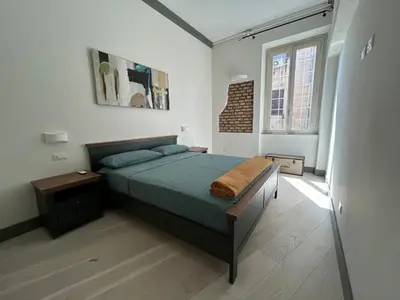 a bedroom with a bed and a large window at Home Domus Castel Sant'Angelo in Rome