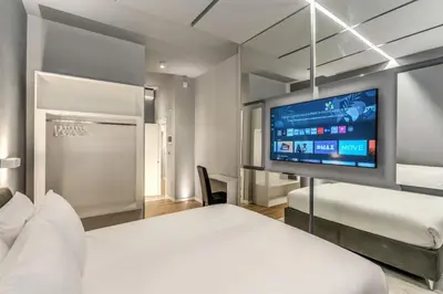 a hotel room with a bed and a flat screen tv at Maison Carrozze in Rome