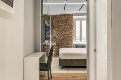 a bedroom with a bed and a desk and a chair at Maison Carrozze in Rome