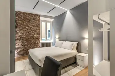 a bedroom with a bed and a brick wall at Maison Carrozze in Rome