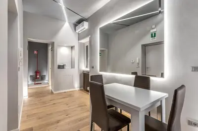 a dining room with a white table and chairs at Maison Carrozze in Rome