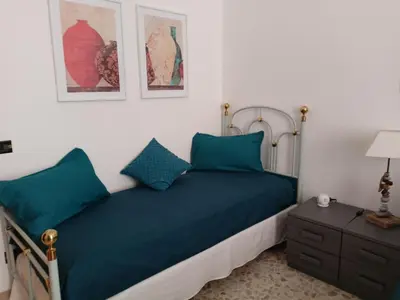 a bedroom with a bed with blue pillows and a nightstand at MURA DI PRATI - Spazioso appartamento per 8 a San Pietro in Rome