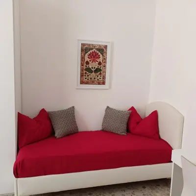 a white couch with red pillows in a room at MURA DI PRATI - Spazioso appartamento per 8 a San Pietro in Rome