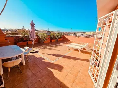 a patio with a table and an umbrella on a balcony at Rooftop Marconi in Rome