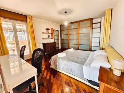 a bedroom with a bed and a desk and a table at Rooftop Marconi in Rome