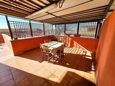 a patio with a table and chairs on a balcony at Rooftop Marconi in Rome