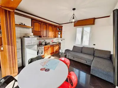 a kitchen and living room with a white table and red chairs at Rooftop Marconi in Rome